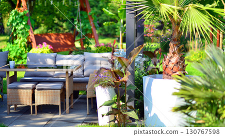 Modern aluminum pergola with stylish garden furniture in a beautiful garden. 130767598