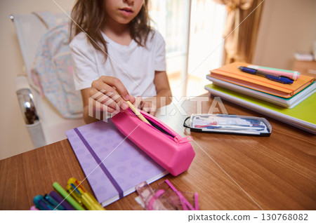 Young Girl Organizing Stationary Items in a Pink Pencil Case on Desk Young Girl Organizing Stationary Items in a Pink Pencil Case on Desk 130768082