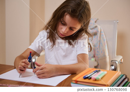 Young Girl Practicing Geometry at Desk with School Supplies and Determination Young Girl Practicing Geometry at Desk with School Supplies and Determination 130768098