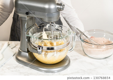 Stand mixer with butter, brown sugar, and other ingredients for Pale Gingerbread Cookies with Subtle Spice Flavor. Glass bowl on the mixer is partially filled. 130768654