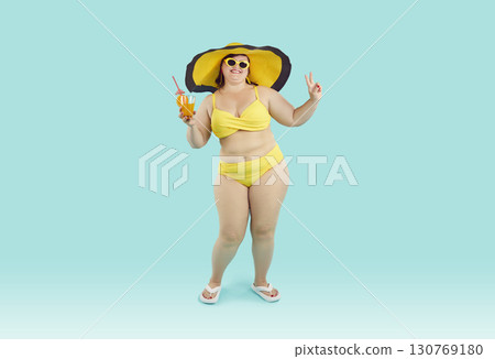 Happy young overweight woman in yellow bikini and sun hat drinking beach cocktail Happy young overweight woman in yellow bikini and sun hat drinking beach cocktail 130769180