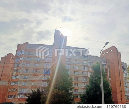 Orange brick apartment building in an optimistic style in bright sunlight representing urban living 130769388