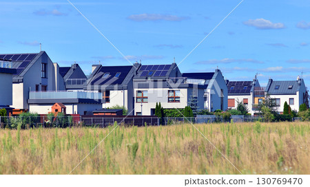 Harmony with nature, eco architecture. Terraced single family homes in newly developed housing estate. The real estate market in the suburbs with lush greenery surrounding. Harmony with nature, eco architecture. Terraced single family homes in newly developed housing estate. The real estate market in the suburbs with lush greenery surrounding. 130769470