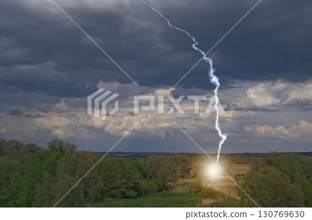 Lightning strike in field in the evening in the countryside 130769630