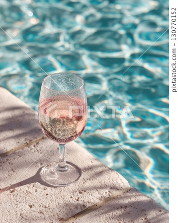 Glass of rose wine by the pool on a sunny day Glass of rose wine by the pool on a sunny day 130770152