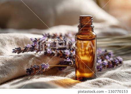 Amber glass bottle with essential lavender oil on linen fabric 130770153