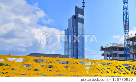 Modern office building with glass facade. Transparent glass wall of office building. Reflection of the blue sky on the facade of the building. Modern office building with glass facade. Transparent glass wall of office building. Reflection of the blue sky on the facade of the building. 130770930