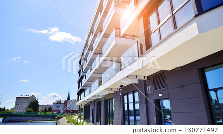 Modern apartment buildings on a sunny day with a blue sky. Facade of a modern apartment building. Modern residential apartment building complex condo. Modern apartment buildings on a sunny day with a blue sky. Facade of a modern apartment building. Modern residential apartment building complex condo. 130771497