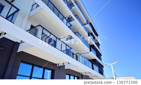 Modern apartment buildings on a sunny day with a blue sky. Facade of a modern apartment building. Modern residential apartment building complex condo. 130771500