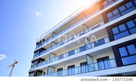 Modern apartment buildings on a sunny day with a blue sky. Facade of a modern apartment building. Modern residential apartment building complex condo. Modern apartment buildings on a sunny day with a blue sky. Facade of a modern apartment building. Modern residential apartment building complex condo. 130771506
