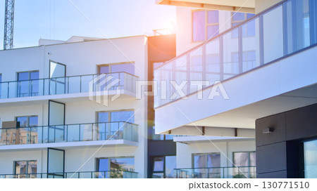 Modern apartment buildings on a sunny day with a blue sky. Facade of a modern apartment building. Modern residential apartment building complex condo. 130771510