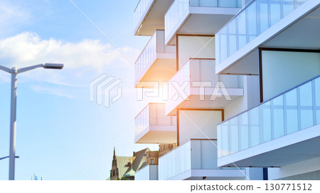 Modern apartment buildings on a sunny day with a blue sky. Facade of a modern apartment building. Modern residential apartment building complex condo. Modern apartment buildings on a sunny day with a blue sky. Facade of a modern apartment building. Modern residential apartment building complex condo. 130771512
