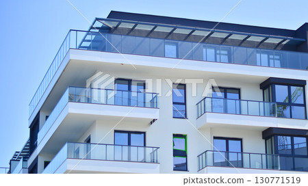 Modern apartment buildings on a sunny day with a blue sky. Facade of a modern apartment building. Modern residential apartment building complex condo. 130771519