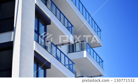 Modern apartment buildings on a sunny day with a blue sky. Facade of a modern apartment building. Modern residential apartment building complex condo. Modern apartment buildings on a sunny day with a blue sky. Facade of a modern apartment building. Modern residential apartment building complex condo. 130771532