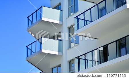 Modern apartment buildings on a sunny day with a blue sky. Facade of a modern apartment building. Modern residential apartment building complex condo. Modern apartment buildings on a sunny day with a blue sky. Facade of a modern apartment building. Modern residential apartment building complex condo. 130771533