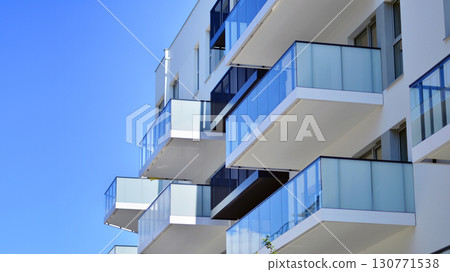 Modern apartment buildings on a sunny day with a blue sky. Facade of a modern apartment building. Modern residential apartment building complex condo. Modern apartment buildings on a sunny day with a blue sky. Facade of a modern apartment building. Modern residential apartment building complex condo. 130771538