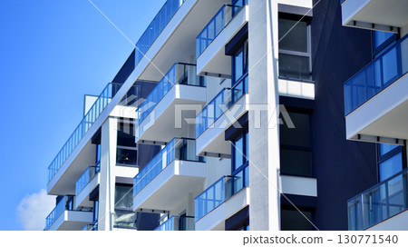 Modern apartment buildings on a sunny day with a blue sky. Facade of a modern apartment building. Modern residential apartment building complex condo. Modern apartment buildings on a sunny day with a blue sky. Facade of a modern apartment building. Modern residential apartment building complex condo. 130771540
