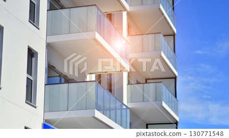 Modern apartment buildings on a sunny day with a blue sky. Facade of a modern apartment building. Modern residential apartment building complex condo. Modern apartment buildings on a sunny day with a blue sky. Facade of a modern apartment building. Modern residential apartment building complex condo. 130771548