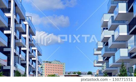 Modern apartment buildings on a sunny day with a blue sky. Facade of a modern apartment building. Modern residential apartment building complex condo. Modern apartment buildings on a sunny day with a blue sky. Facade of a modern apartment building. Modern residential apartment building complex condo. 130771551