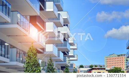 Modern apartment buildings on a sunny day with a blue sky. Facade of a modern apartment building. Modern residential apartment building complex condo. 130771554
