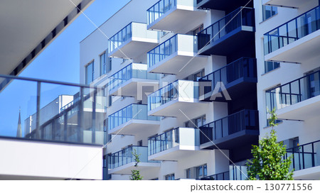 Modern apartment buildings on a sunny day with a blue sky. Facade of a modern apartment building. Modern residential apartment building complex condo. 130771556