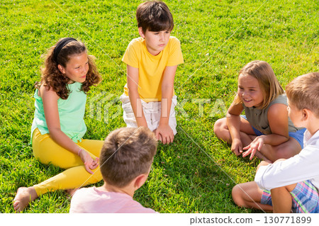 Group of kids sitting on grass 130771899