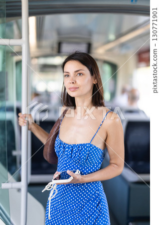 Young girl standing in train holding phone in hand 130771901