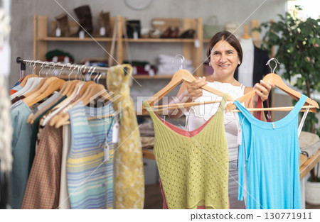 Latin woman customer turn over and choose something summer cloth in store, Latin woman customer turn over and choose something summer cloth in store, 130771911