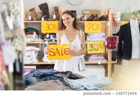 Young woman holding a sign that says sale 130771934