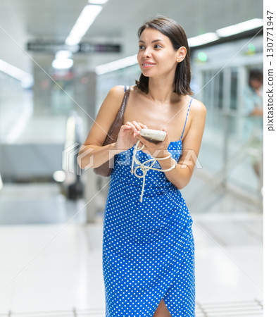 Adult woman with phone at escalator of metro station 130771947