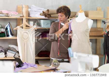 Fashion designer communicates with the client via video call and shows a sample of clothes 130771949