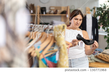 Latin woman customer turn over and choose high heels shoes in store 130771968