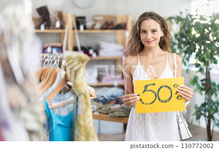 Woman holding poster with 50 percent discount Woman holding poster with 50 percent discount 130772002