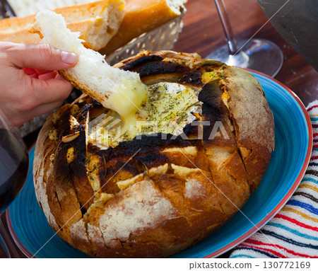 Camembert fondue in bread bowl Camembert fondue in bread bowl 130772169