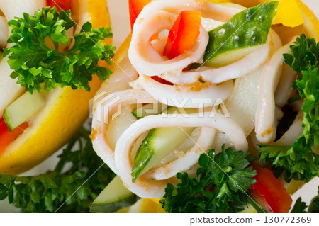 Tropical salad with squids served in lemon with cucumbers and pepper 130772369