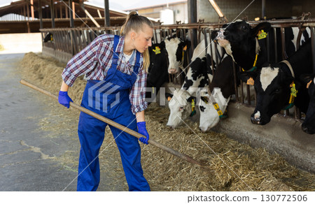 Young female farmer working with pitchfork 130772506