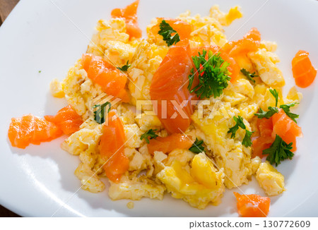 Tasty cooked omlette fried with salmon served at plate on table Tasty cooked omlette fried with salmon served at plate on table 130772609