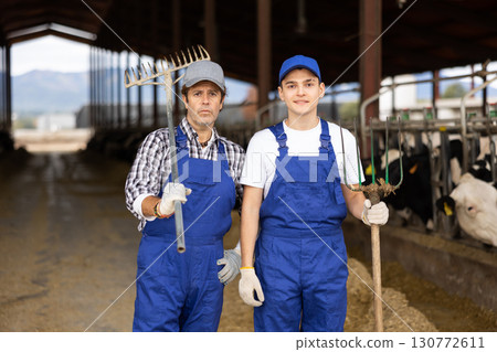 Portrait of boy and man farmers on dairy farm Portrait of boy and man farmers on dairy farm 130772611