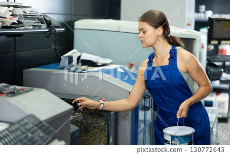 Girl of warehouse store construction and repair materials mix different shades and colors in device 130772643