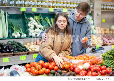 Young woman and young guy choose tomatoes 130772650