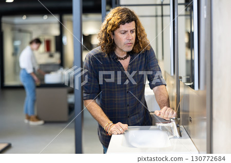 Confident male customer choosing bathroom sink in hardware store 130772684