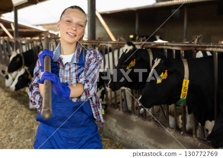 Young female farmer standing with pitchfork 130772769