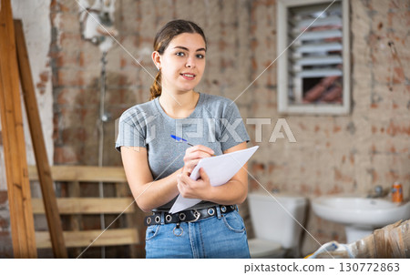 Woman making notes on indoor construction site Woman making notes on indoor construction site 130772863