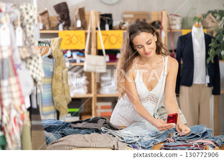 Woman scans barcode labels on pants 130772906