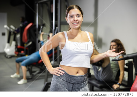 Portrait of slim woman smiling after work out in gym Portrait of slim woman smiling after work out in gym 130772975