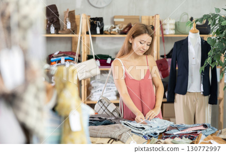 Woman shopping in clothing department, buying denim pantalones 130772997
