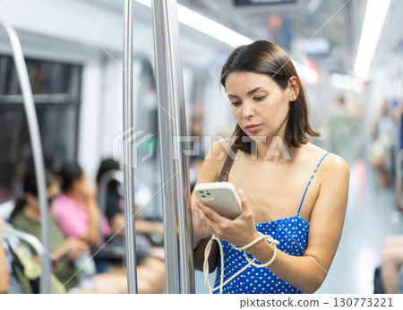 Young girl scrolling phone standing in wagon 130773221