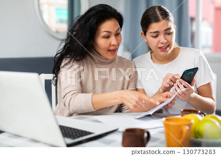Worried LGBT couple working with papers 130773283