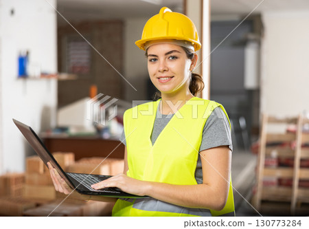 Female engineer using laptop in apartment 130773284