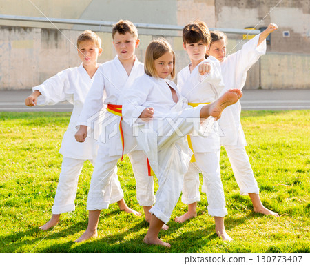 Children training a new moves during karate class at summer outdoors 130773407